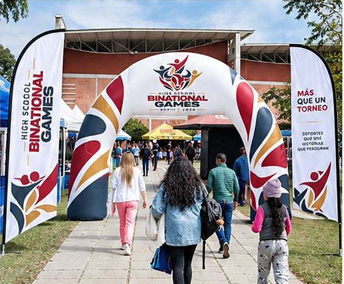 Arco de entrada y banderas tipo feather con la identidad del evento.